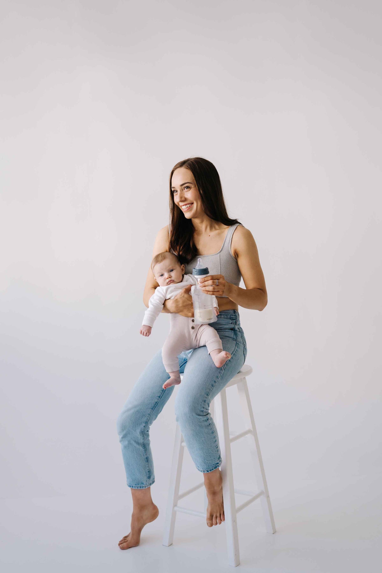 Bilde av kvinne og baby med oppbevaringsposer for morsmelk fra Lola&Lykke